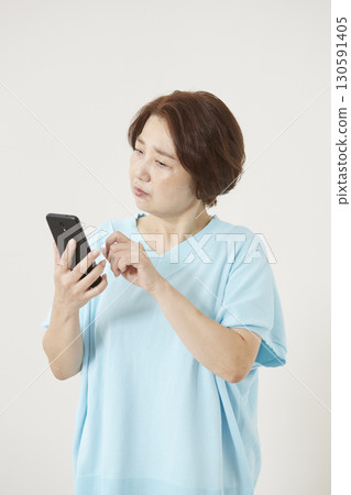 Senior woman operating a smartphone Senior woman operating a smartphone 130591405