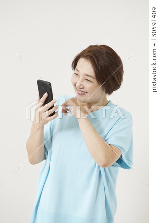 Senior woman operating a smartphone Senior woman operating a smartphone 130591409