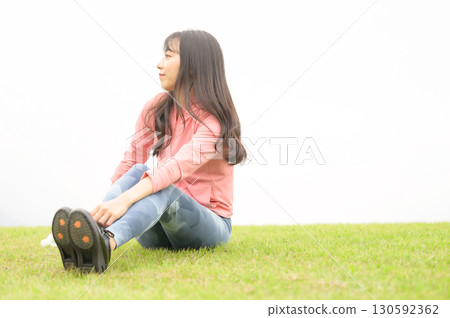 一位女士在草地上運動後休息 一位女士在草地上運動後休息 130592362