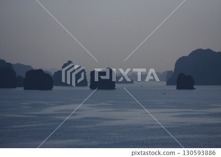 The strange rock formations of Halong Bay, shrouded in mist, look like ink paintings. 130593886