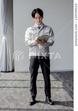 使用平板電腦的工作服的男人 使用平板電腦的工作服的男人 130594020