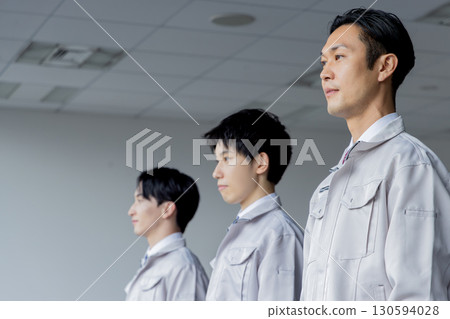 Men in work clothes looking up in a line Men in work clothes looking up in a line 130594028