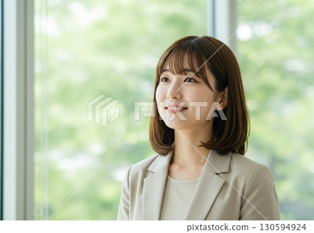 A female business person with a positive expression in a bright office 130594924