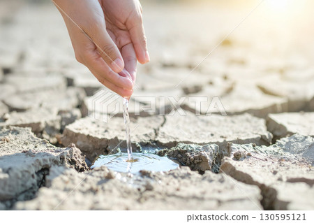 pouring water on arid and sterile ground 130595121