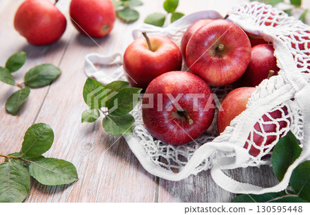 Fresh red apples resting in reusable shopping bag promoting sustainability 130595448