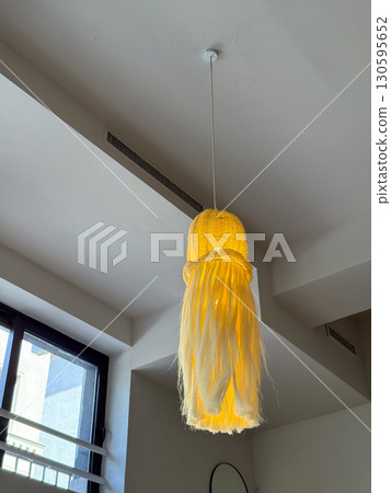 Hanging decorative lamp in interior. Warm light, creative design and cozy atmosphere in modern space. Hanging decorative lamp in interior. Warm light, creative design and cozy atmosphere in modern space. 130595652