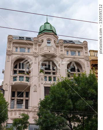 Historical building in Belgrade with green dome, balconies and ornate decorative details. Classic urban architecture and cultural landmark. 130595712