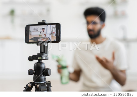Adult man creating content for video blog discussing fitness and importance of hydration Adult man creating content for video blog discussing fitness and importance of hydration 130595883