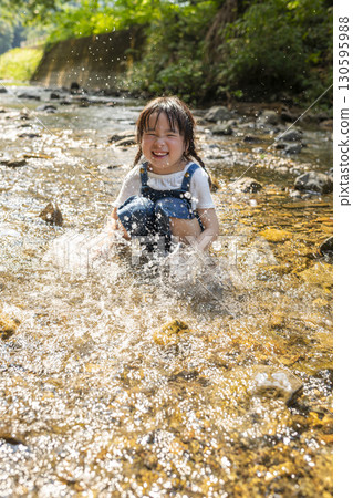 Girl enjoying playing in the river 130595988