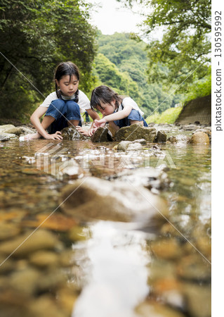 Sisters enjoying a summer vacation in the river 130595992