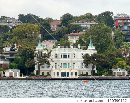 Elegant waterfront mansion with distinctive towers in Istanbul. Architecture, heritage, luxury, and cultural identity on Bosphorus Strait. 130596112