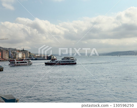 Passenger boats navigating the Bosphorus with bridge in the background. Transportation, tourism, and urban maritime life in Istanbul. 130596250