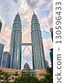 Nov 20, 2019 - Kuala Lumpur, Malaysia: Petronas Twin Towers with skybridge in urban skyline at day under dramatic cloudy blue sky. Scenic cityscape with lush park, modern Suria KLCC shopping mall in 130596433
