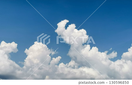 Fluffy white clouds scattered across a bright blue sky creating serene atmosphere Fluffy white clouds scattered across a bright blue sky creating serene atmosphere 130596850