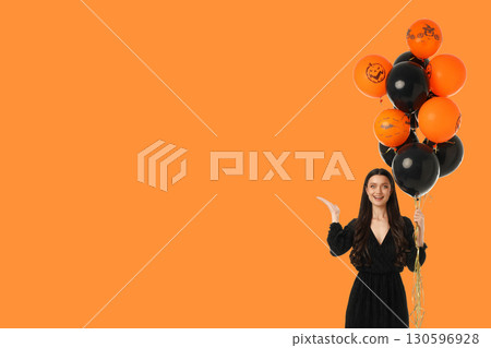 Young woman celebrating Halloween with colorful balloons in hand Young woman celebrating Halloween with colorful balloons in hand 130596928