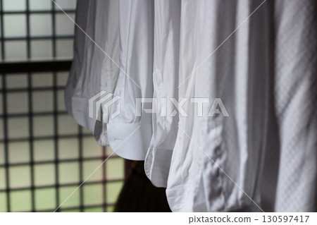 White shirts lined up to dry indoors. White shirts lined up to dry indoors. 130597417