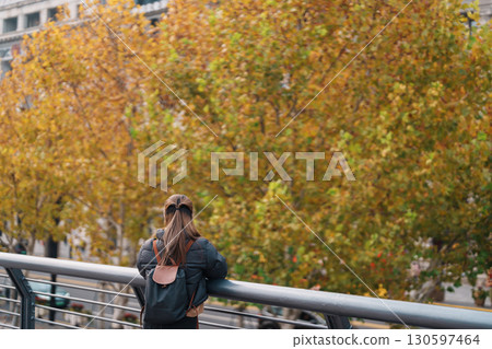 woman traveler visiting in Shanghai, China. Happy Female Tourist sightseeing Shanghai view in The Bund of Shanghai in Autumn season. landmark and popular for tourism attractions. Travel and Vacation 130597464