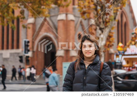 woman traveler visiting in Shanghai, China. Happy Female Tourist sightseeing Shanghai Union Church view in autumn season. landmark and popular for tourism attractions. Travel and vacation 130597469