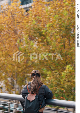 woman traveler visiting in Shanghai, China. Happy Female Tourist sightseeing Shanghai view in The Bund of Shanghai in Autumn season. landmark and popular for tourism attractions. Travel and Vacation 130597483