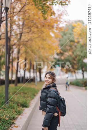 woman traveler visiting in Shanghai, China. Happy Female Tourist sightseeing Shanghai view in The Bund of Shanghai in Autumn season. landmark and popular for tourism attractions. Travel and Vacation 130597484