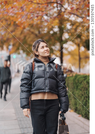 woman traveler visiting in Shanghai, China. Happy Female Tourist sightseeing Shanghai view in The Bund of Shanghai in Autumn season. landmark and popular for tourism attractions. Travel and Vacation 130597485