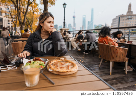 woman traveler visiting in Shanghai, China. Happy Female Tourist enjoy eating and drinking in Restaurant and Coffee bar. landmark and popular for tourism attractions. Travel and vacation concept 130597486
