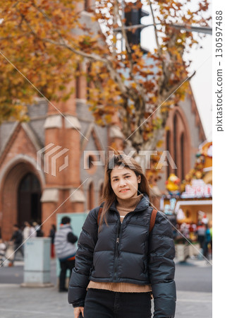 woman traveler visiting in Shanghai, China. Happy Female Tourist sightseeing Shanghai Union Church view in autumn season. landmark and popular for tourism attractions. Travel and vacation 130597488