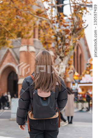 woman traveler visiting in Shanghai, China. Happy Female Tourist sightseeing Shanghai Union Church view in autumn season. landmark and popular for tourism attractions. Travel and vacation 130597489