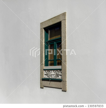 Window on wall. Classic rectangular green frame, decorative iron grille, stylish vintage design. 130597833