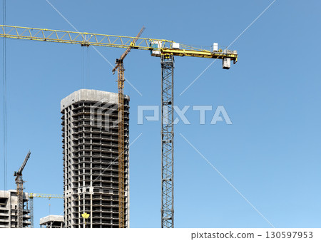Construction site with tall unfinished highrise building, concrete structure, windows, scaffold, Construction site with tall unfinished highrise building, concrete structure, windows, scaffold, 130597953