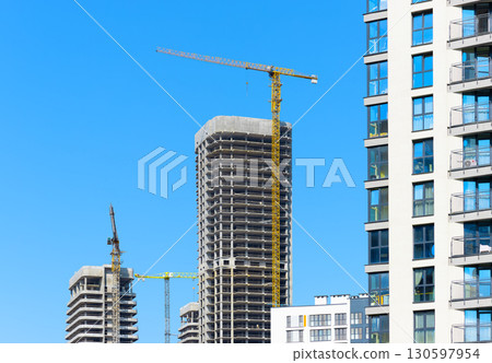 Construction site with unfinished highrise skyscraper, concrete and steel structure, yellow 130597954