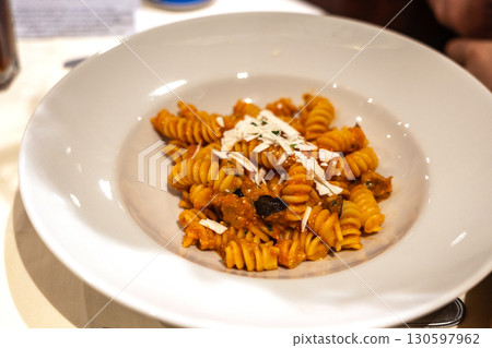 Fusilli with eggplant and cheese on a white plate Fusilli with eggplant and cheese on a white plate 130597962