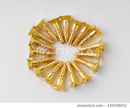 Yellow metal screws pile. Gold bolts close up 130598052
