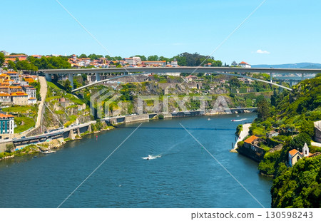 Scenic view of Porto, Portugal with Douro River, modern bridge architecture, flowing water, green 130598243