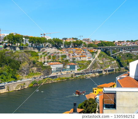 Sunny day in Porto, Portugal with Douro River, boats, hillside buildings, red rooftops, medieval Sunny day in Porto, Portugal with Douro River, boats, hillside buildings, red rooftops, medieval 130598252