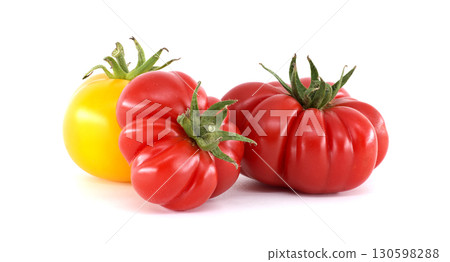 Three vibrant heirloom tomatoes in shades of red and yellow on a white backdrop. Three vibrant heirloom tomatoes in shades of red and yellow on a white backdrop. 130598288