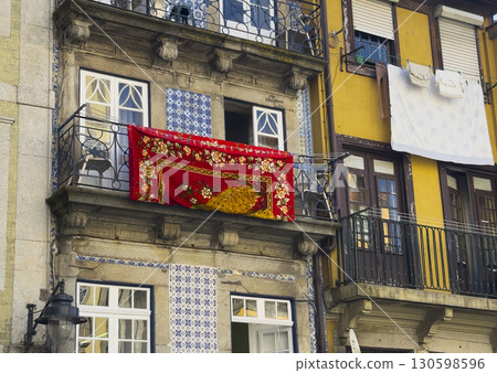 Balconies of traditional houses in Porto with azulejo tiles and colorful facades. A bright red 130598596