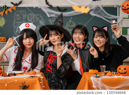 A group of four high school girls are enjoying a Halloween party in their classroom during the school festival, dressed up in Halloween costumes. 130598666