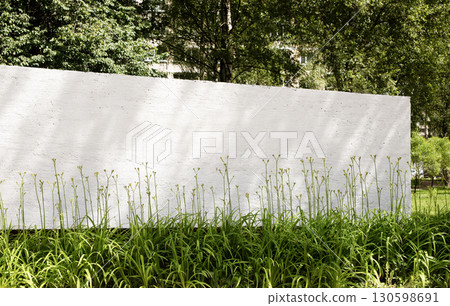 White stone wall mockup with blank banner in outdoor forest environment. Sunny daylight scene with White stone wall mockup with blank banner in outdoor forest environment. Sunny daylight scene with 130598691