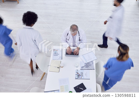 Doctor, man and laptop in busy hospital for medicine research, surgery schedule management or medical life insurance. Top view, healthcare worker and surgeon on technology with motion blur coworkers Doctor, man and laptop in busy hospital for medicine research, surgery schedule management or medical life insurance. Top view, healthcare worker and surgeon on technology with motion blur coworkers 130598811