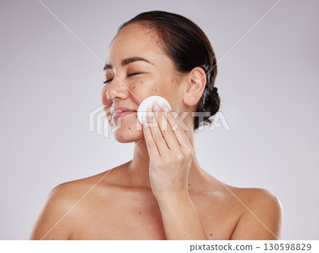 Face, makeup cotton and woman with eyes closed in studio isolated on a gray background. Skincare hygiene, beauty aesthetics and happy female model with facial pad or product for cleaning cosmetics. Face, makeup cotton and woman with eyes closed in studio isolated on a gray background. Skincare hygiene, beauty aesthetics and happy female model with facial pad or product for cleaning cosmetics. 130598829