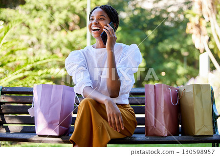 Phone call, happy or black woman with shopping, luxury sale or retail bags in Paris park with smile. 5g network, fashion or girl with smartphone for comic communication or networking in city bench 130598957