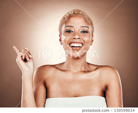 Black woman, portrait and beauty cream with hand pointing at mockup on brown background for dermatology. Happy model smile in studio for skincare, cosmetic and facial glow space for product placement Black woman, portrait and beauty cream with hand pointing at mockup on brown background for dermatology. Happy model smile in studio for skincare, cosmetic and facial glow space for product placement 130599014