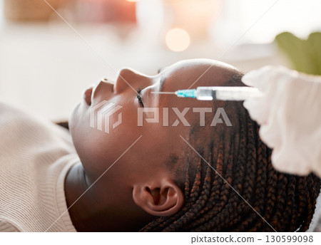 Face, needle and collagen, black woman at spa with injection for skincare and beauty treatment. Dermatology, cosmetics and person at salon with dermal syringe in skin for anti aging facial process. 130599098
