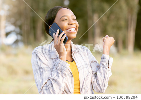 African woman, celebrate and fist with phone call, outdoor or smile for winning, success or goal in summer. Adventure, smartphone conversation or good news for girl in sunshine, forest or celebration African woman, celebrate and fist with phone call, outdoor or smile for winning, success or goal in summer. Adventure, smartphone conversation or good news for girl in sunshine, forest or celebration 130599294
