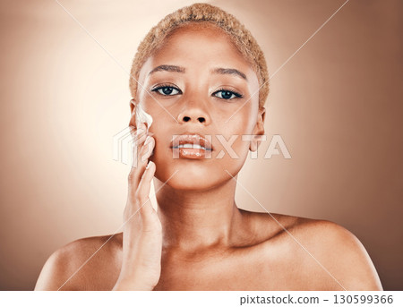 Black woman, hand on face and portrait with cream on brown background for dermatology cosmetics. Aesthetic model person in studio for skincare, beauty and facial glow with clean and healthy skin 130599366