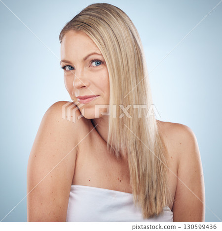 Skincare, beauty and portrait of a woman with hair care isolated on a blue background in a studio. Spa, wellness and cosmetology model with facial makeup, cosmetics and dermatology on a backdrop 130599436