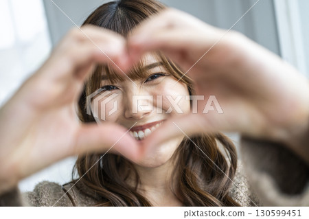 一個手工製作心臟的年輕女子 一個手工製作心臟的年輕女子 130599451