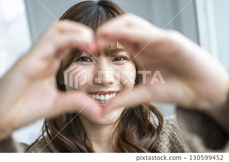 一個手工製作心臟的年輕女子 130599452