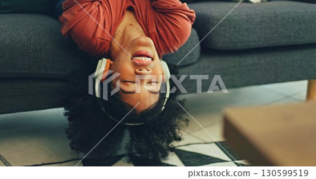 Woman lying on sofa with headphones, singing in living room and relax with streaming radio service. Music, energy and girl on couch in home listening to audio with internet, technology and freedom. 130599519